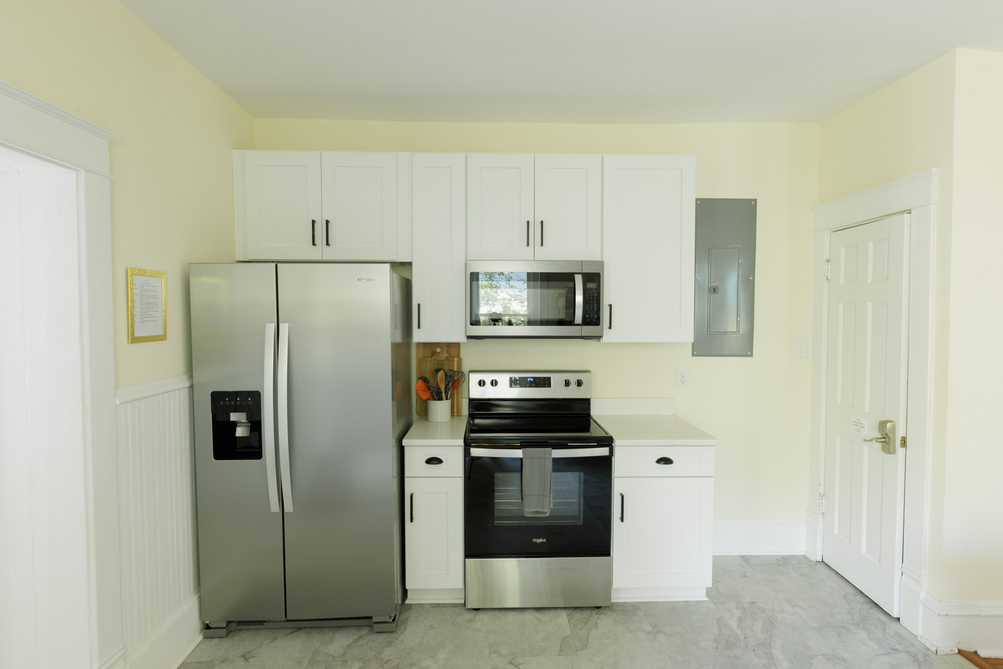 Stove, microwave, refrigerator, and cooking essentials.