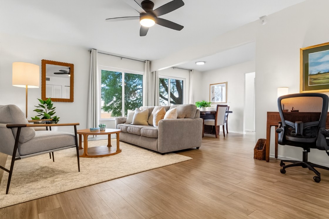 Inviting and open main living space with ceiling fan, plush seating, and plenty of natural light.