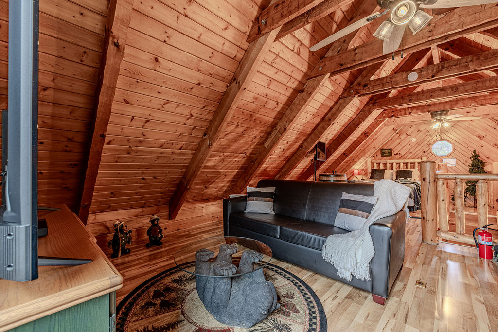 Relax in the inviting loft lounge with a TV, comfy seating, and rustic charm.