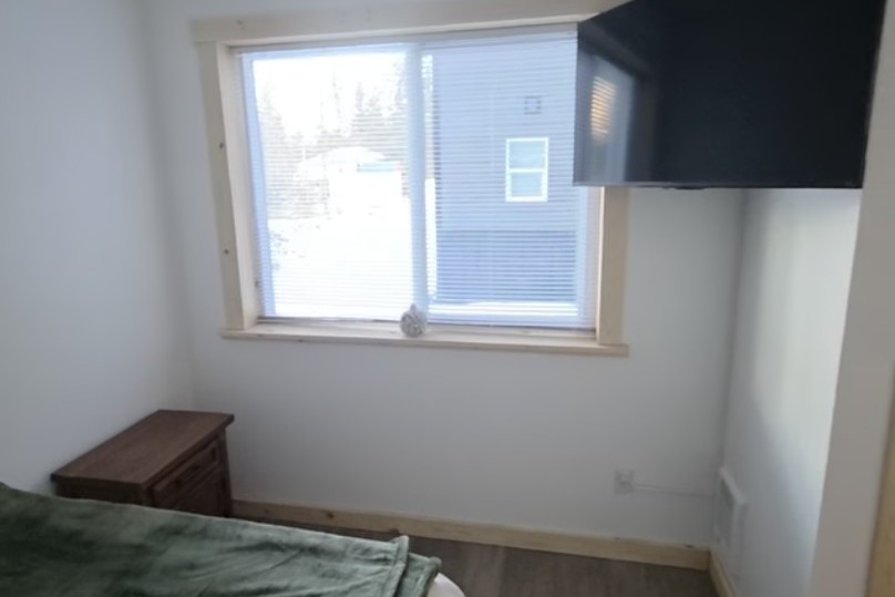 Bedroom on main floor includes a Queen Size Bed, nightstand, closet and TV.