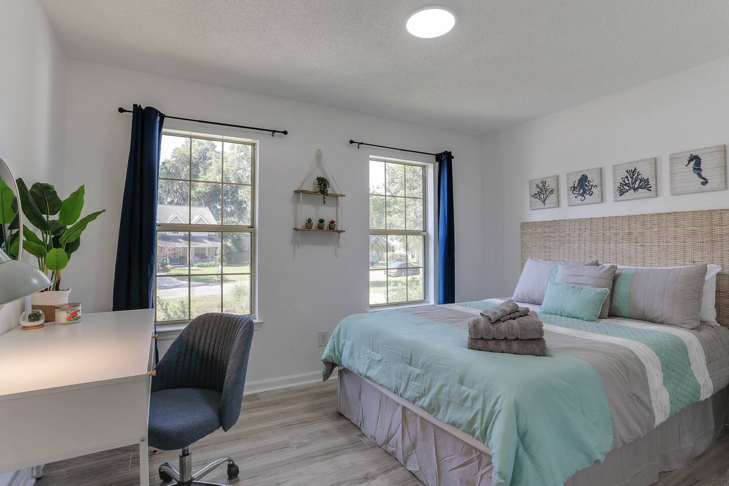 Bright and inviting, the second bedroom features a cozy queen bed, a convenient desk, and large windows that fill the space with natural sunlight.