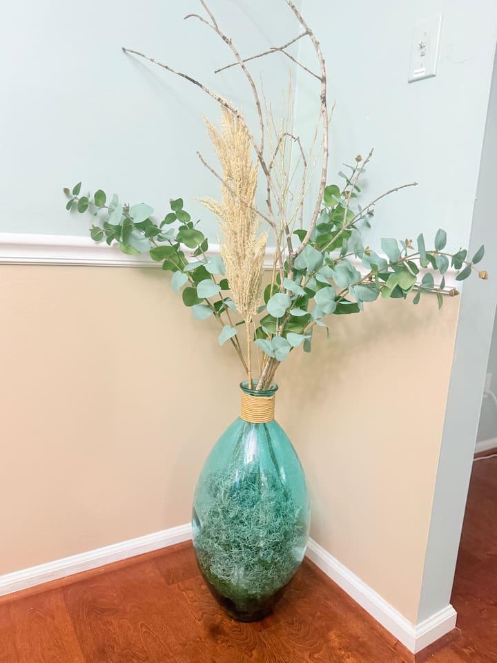 A decorative vase with greenery adds a fresh, peaceful element to this thoughtfully styled corner.  