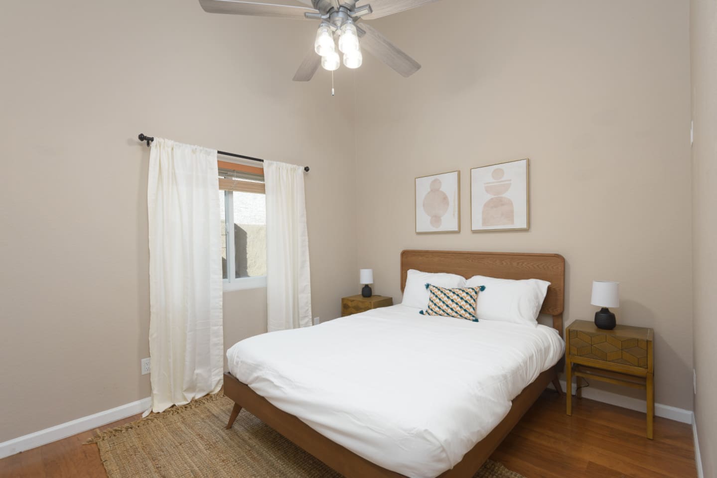 Guest Bedroom 2 with a queen bed, ceiling fan, bedside tables, and a calm setup for a comfortable stay.