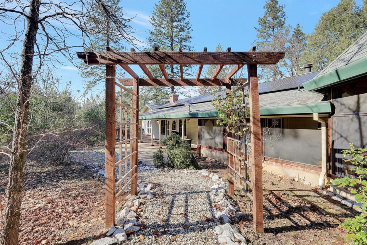 Screened porch and wooded side yard with patio seating and a quiet outdoor path.
