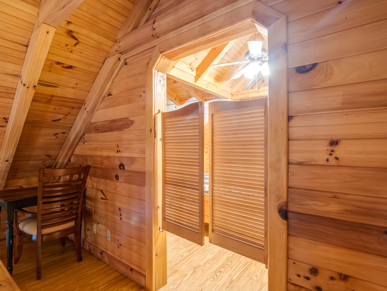 Additional view of upstairs loft, showcasing a writing nook and saloon doors leading to upstairs bedroom