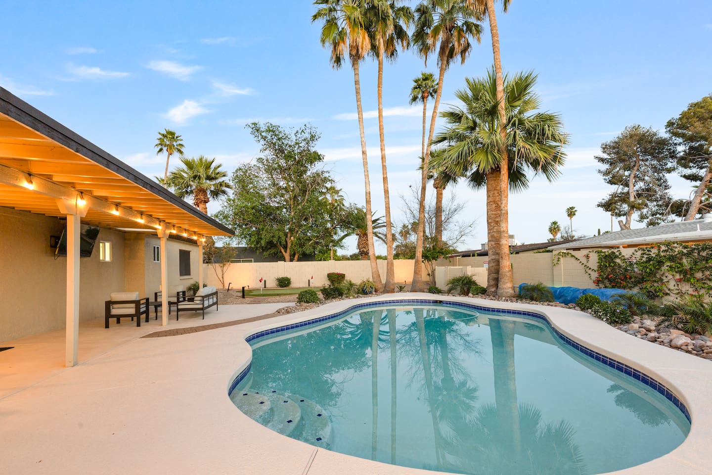 Private pool surrounded by palm trees and outdoor seating