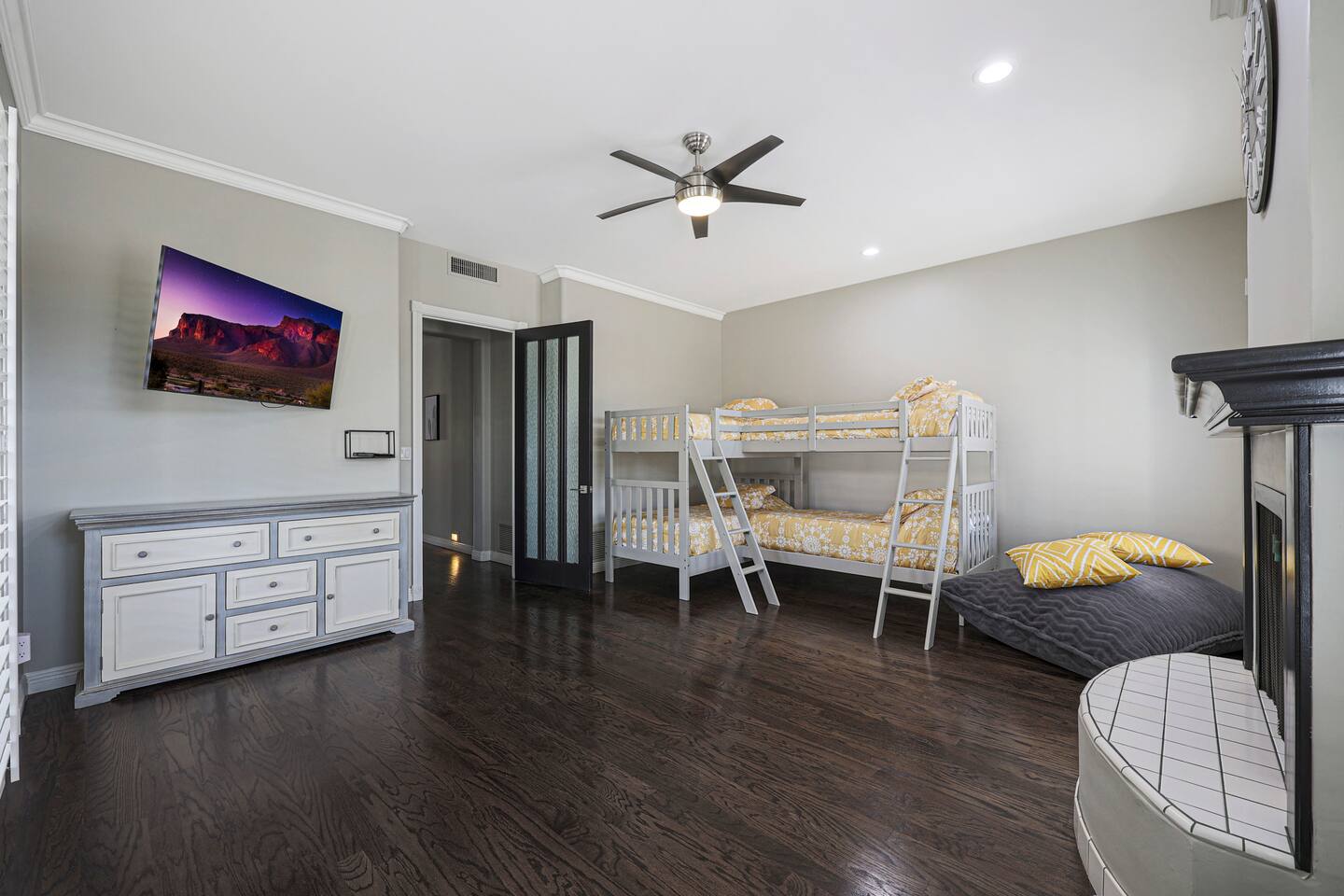 Perfect for kids or teens, this bright and spacious bunk room features stylish twin-over-twin beds, a smart TV, a built-in fireplace, and a cozy lounge area—designed for comfort and fun.