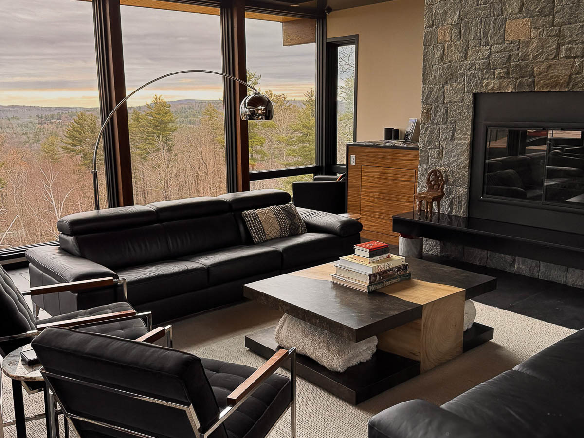 Living room seating area at Sunset Falls &mdash; coffee table books, layered seating, Berkshires