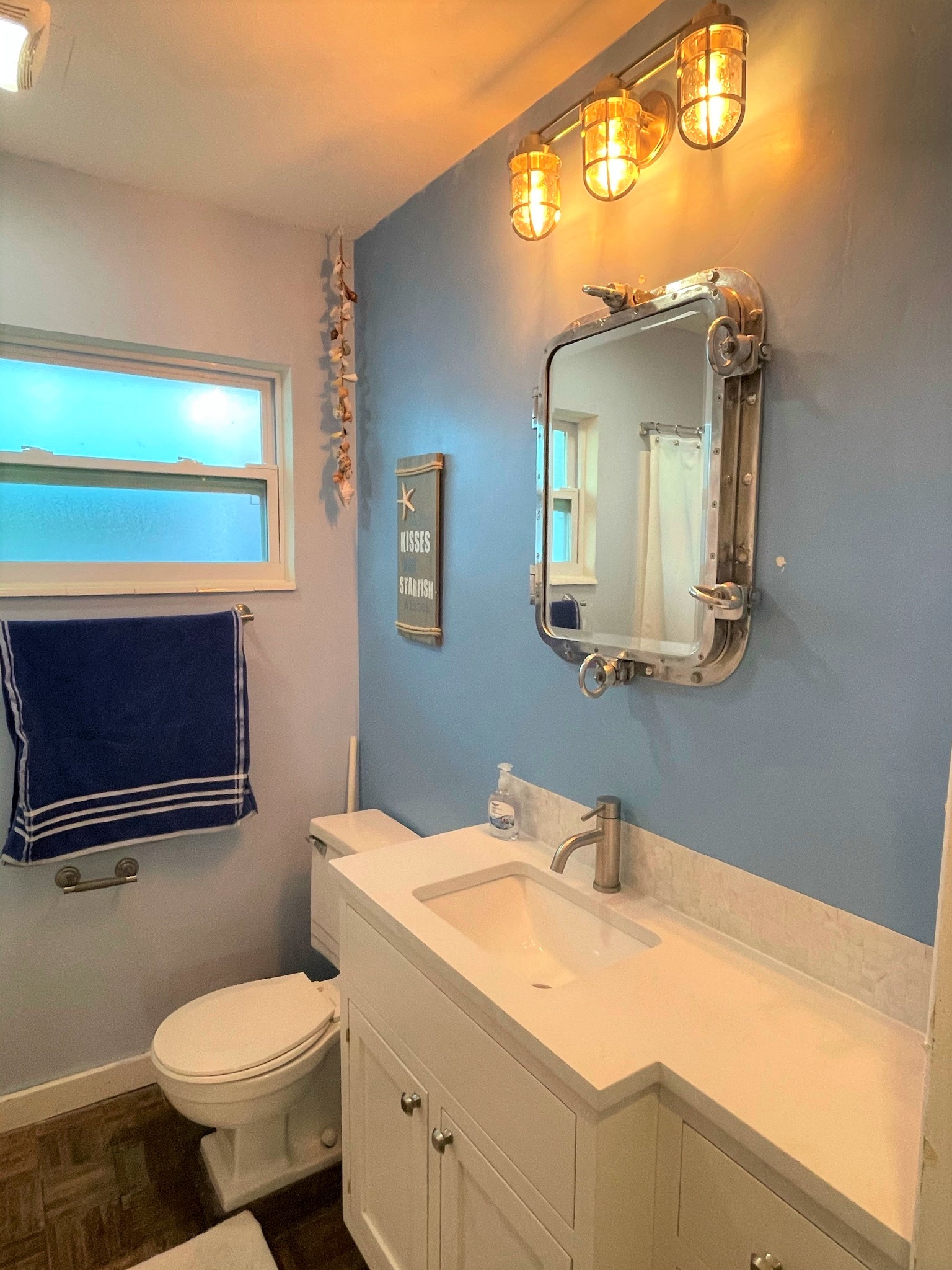 Main Bathroom with real ship port hole converted to a medicine cabinet and nautical lighting