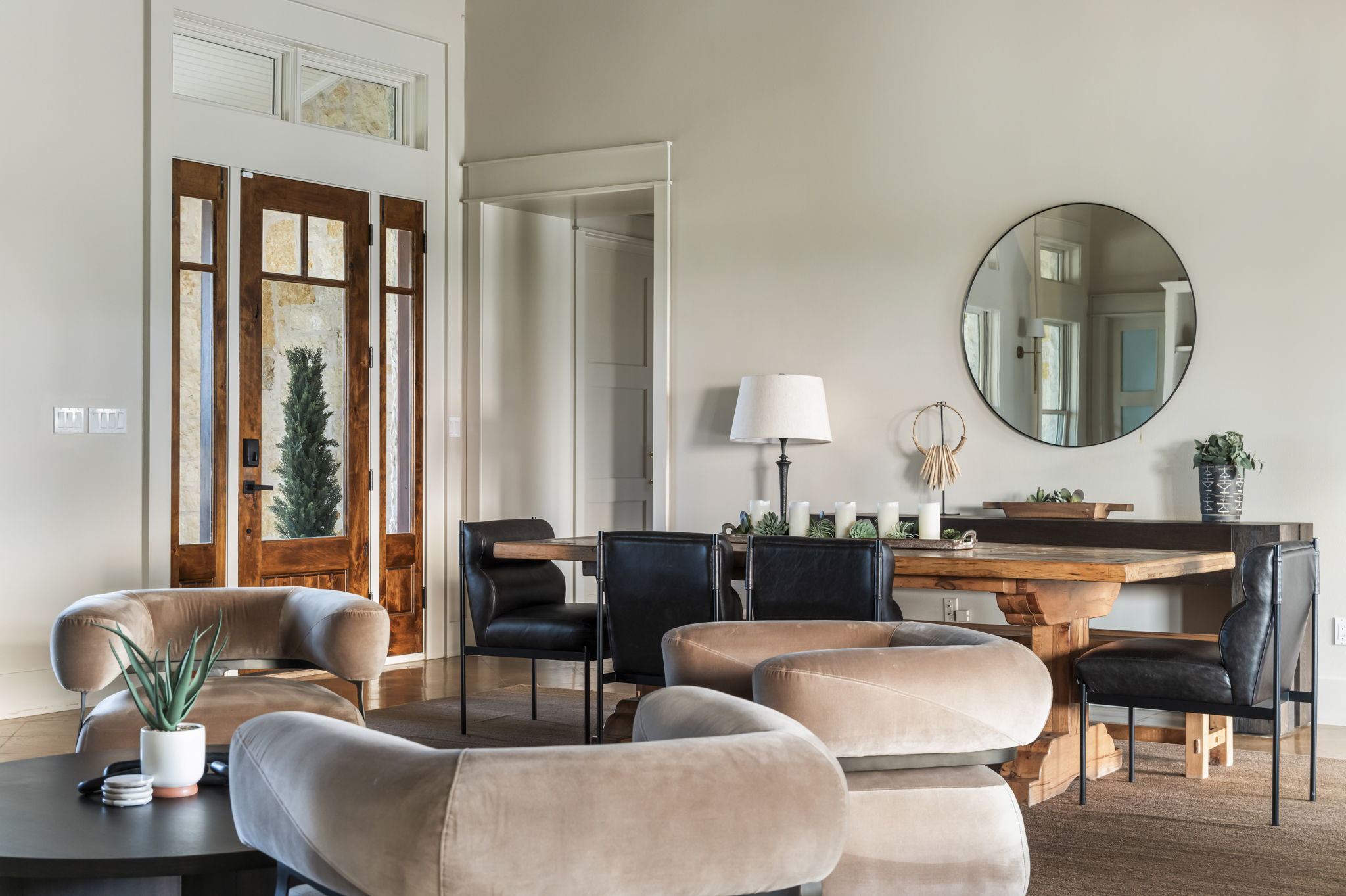 A captivating round mirror reflects the light and adds a touch of modern elegance to this inviting living space.