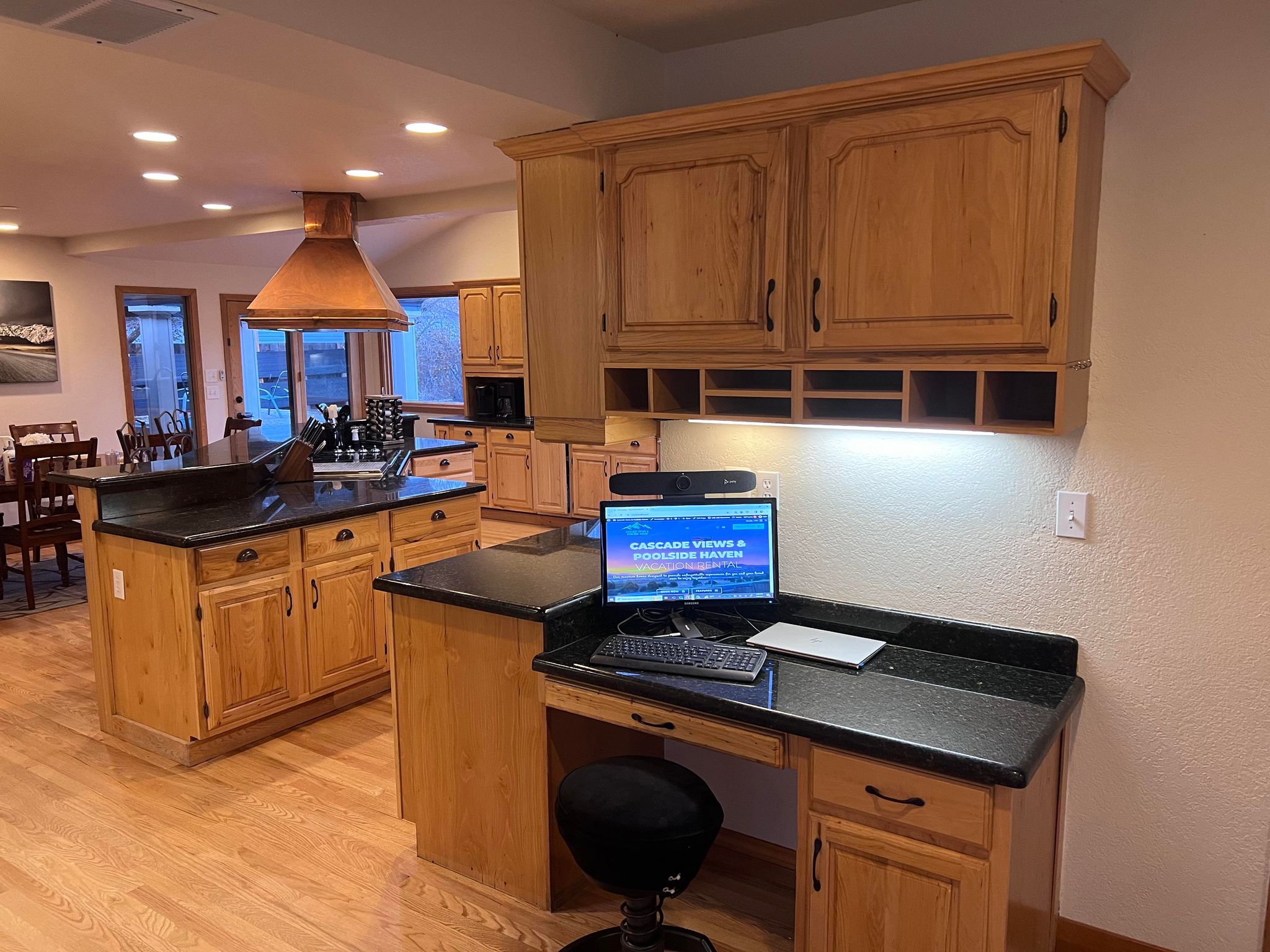 Perfect work from home desk located next to the kitchen with monitor and camera.