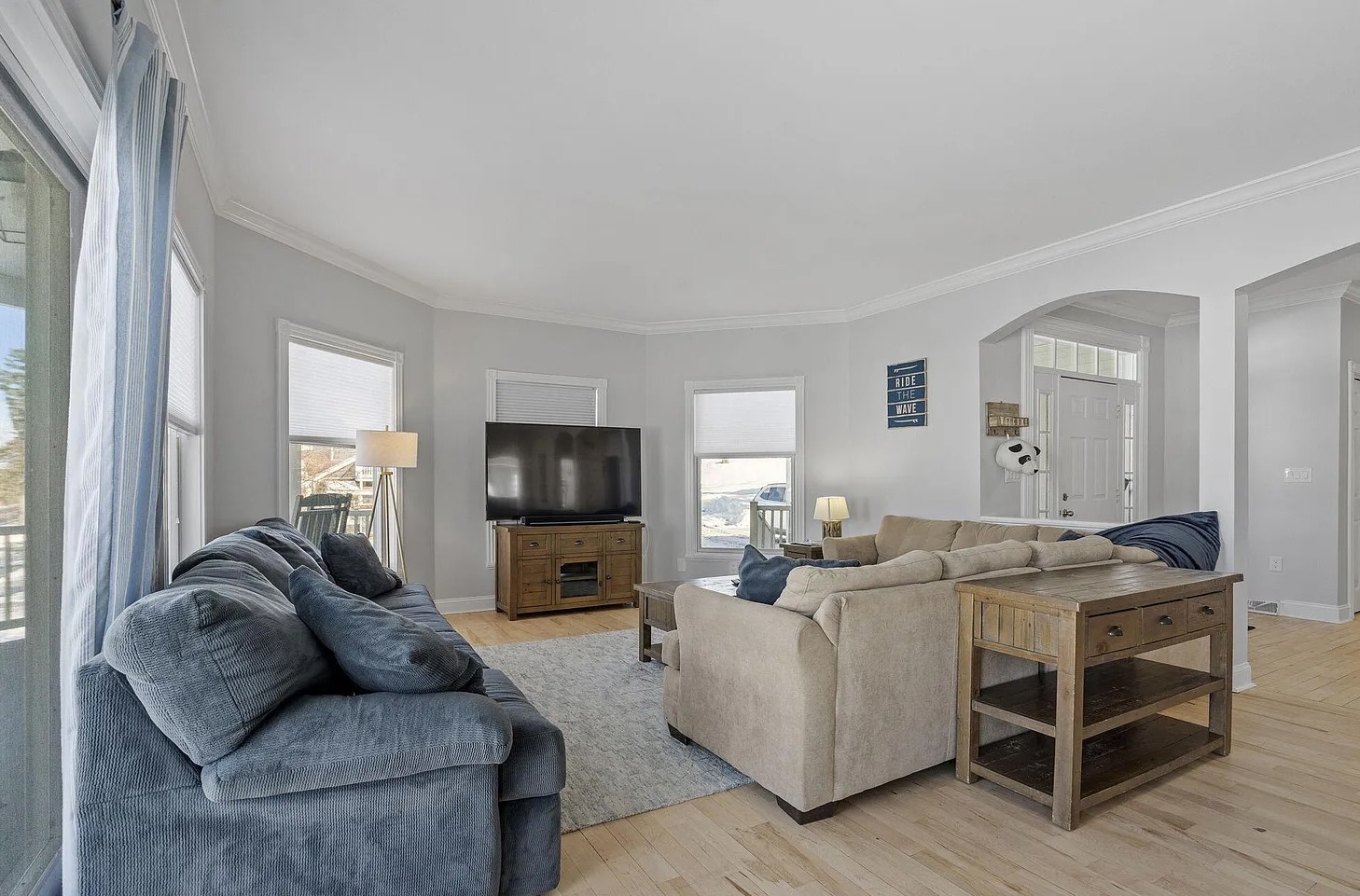 The perfect gathering place - this first-floor living room offers two couches, a big-screen TV, and breathtaking views of the lake.