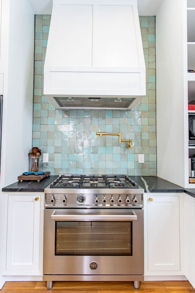 A modern kitchen featuring a stove with an oven, complemented by a built-in exhaust above for ventilation.