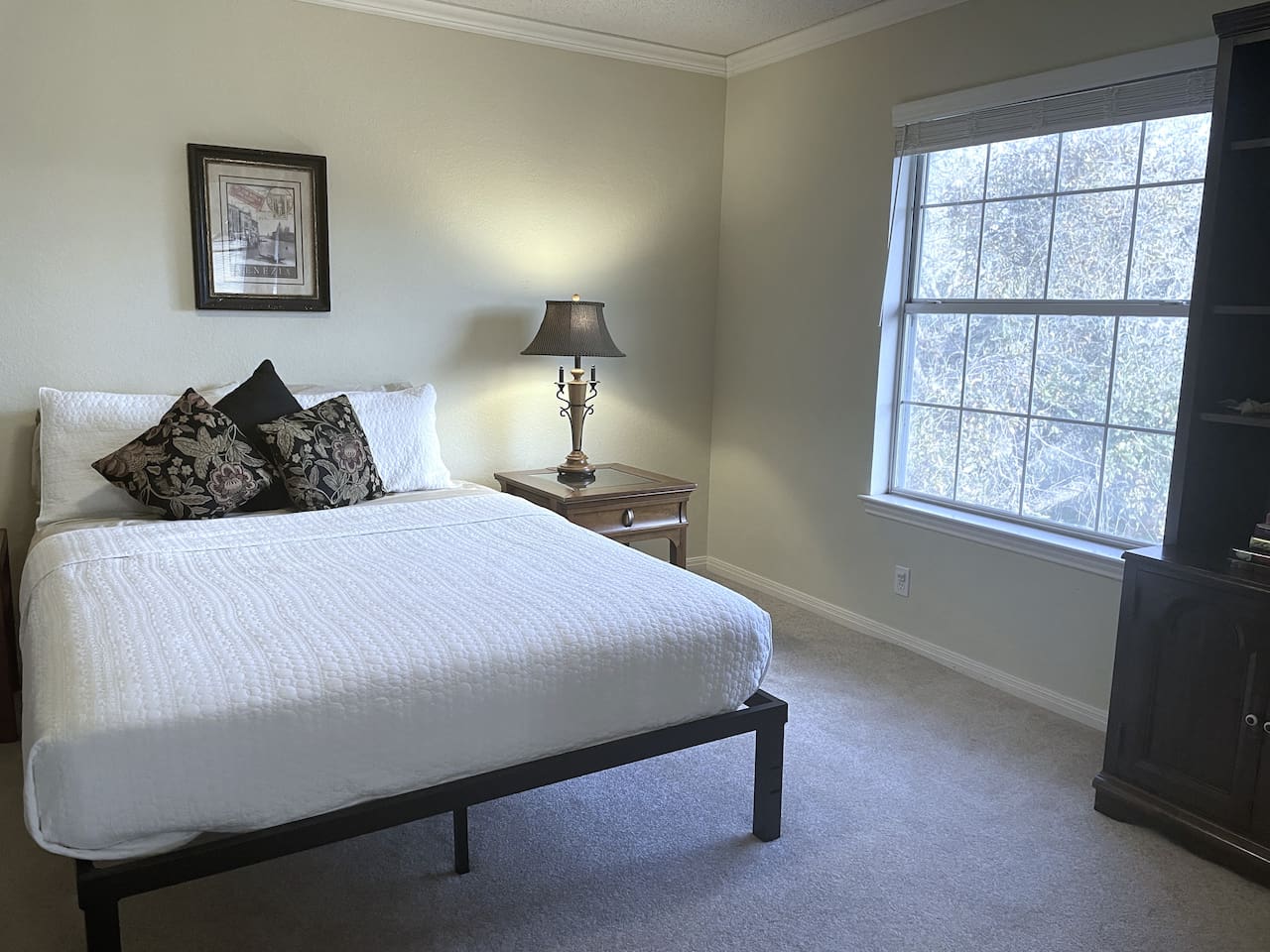 One of five private bedrooms, 'Room With A View' features queen sleeping, bedside charging stations, hanging and drawer space for clothing,  and an expansive treetop view.