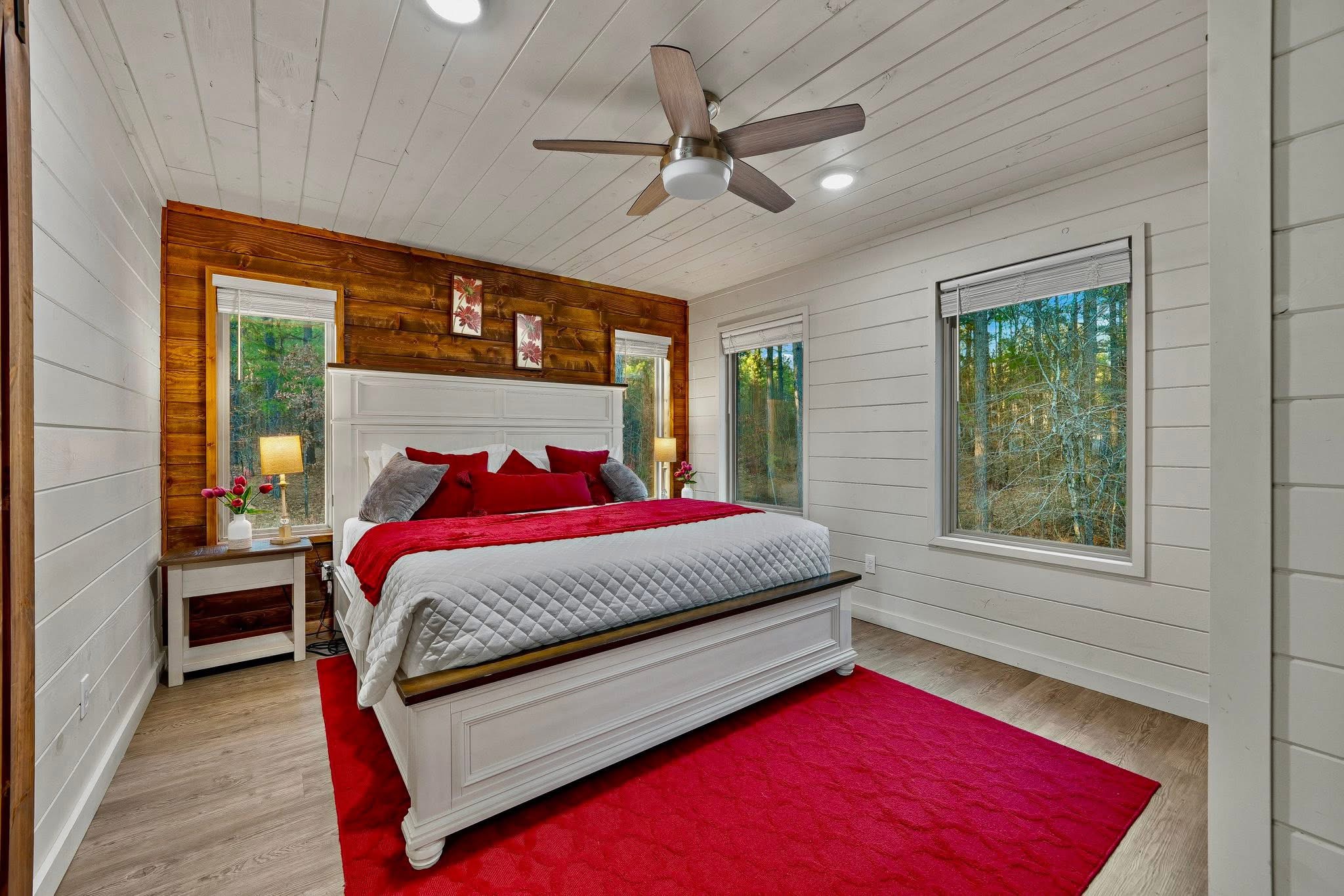 Unwind in style! Bedroom #3 upstairs offers a cozy red ambiance and a picturesque window view.