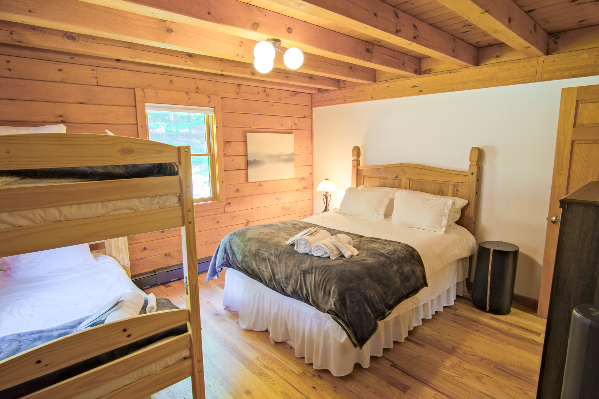 Offering a full size bed and a set of twin bunk beds, this second guest bedroom is perfect for a family, blending coziness and luxurious feel