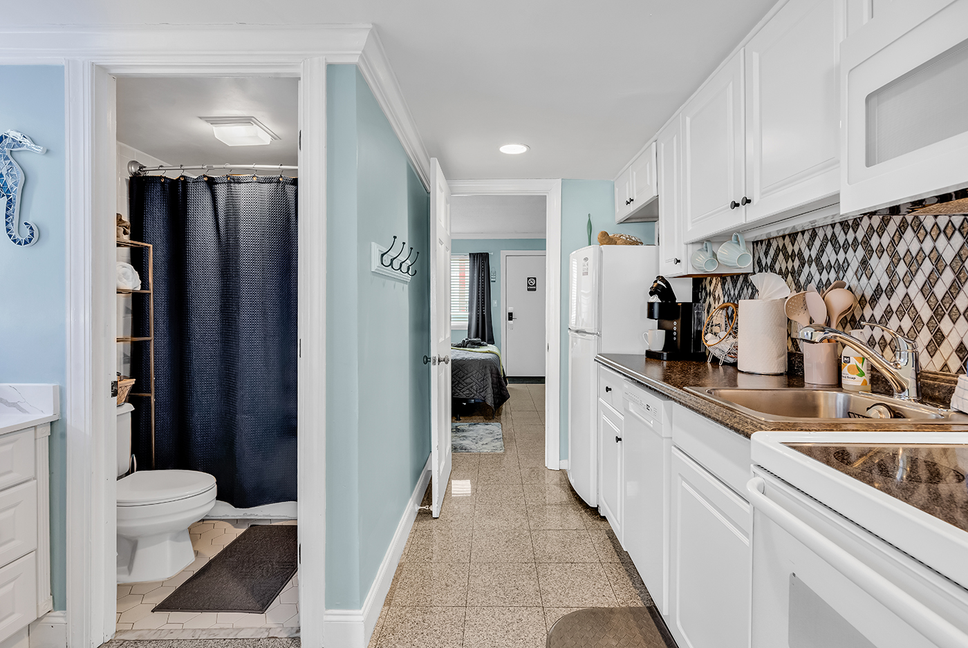 Entry hallway with bathroom on the left and kitchen on the right