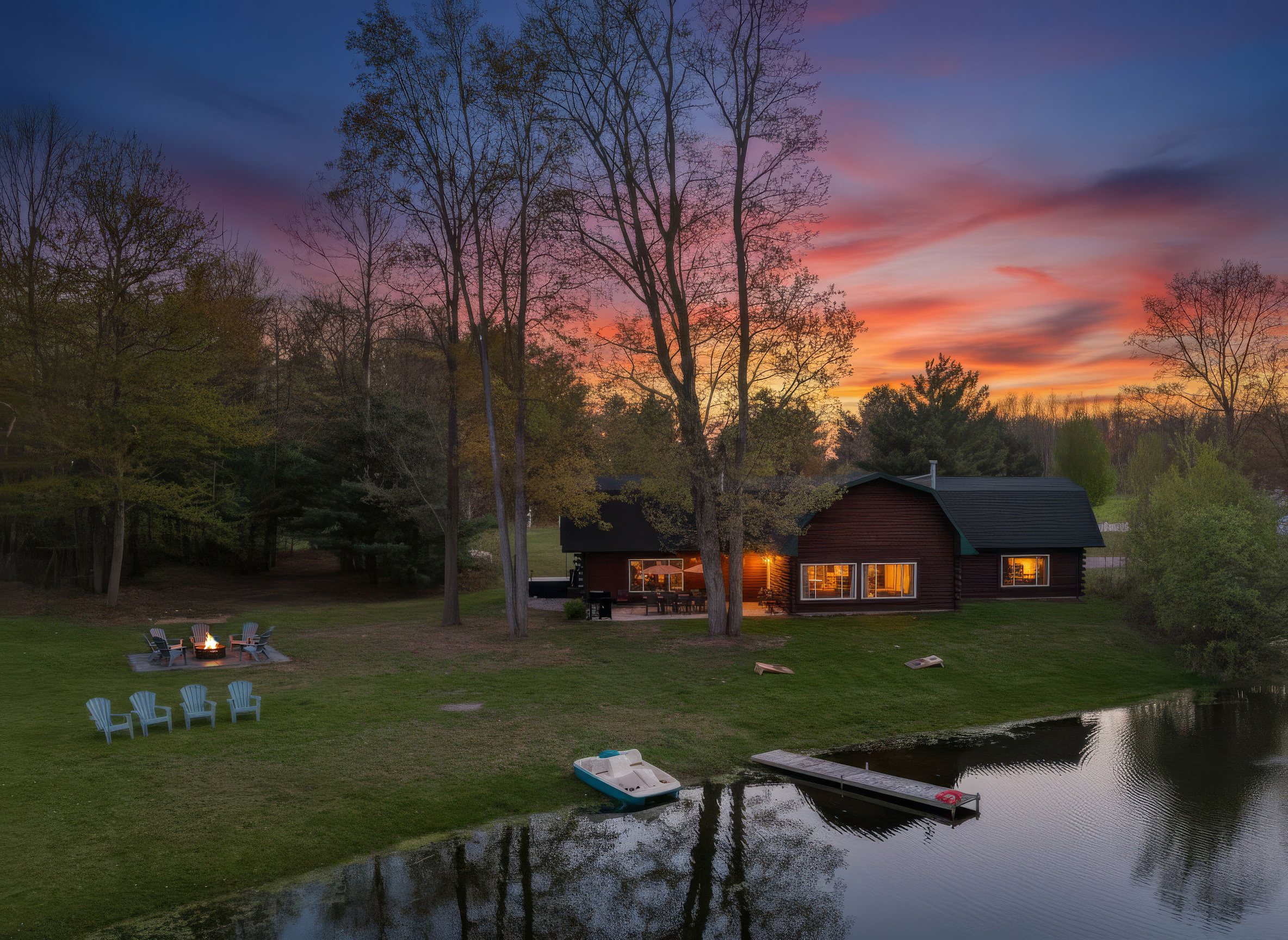 View of dock, outdoor seating, fire pit and our home from the pond.