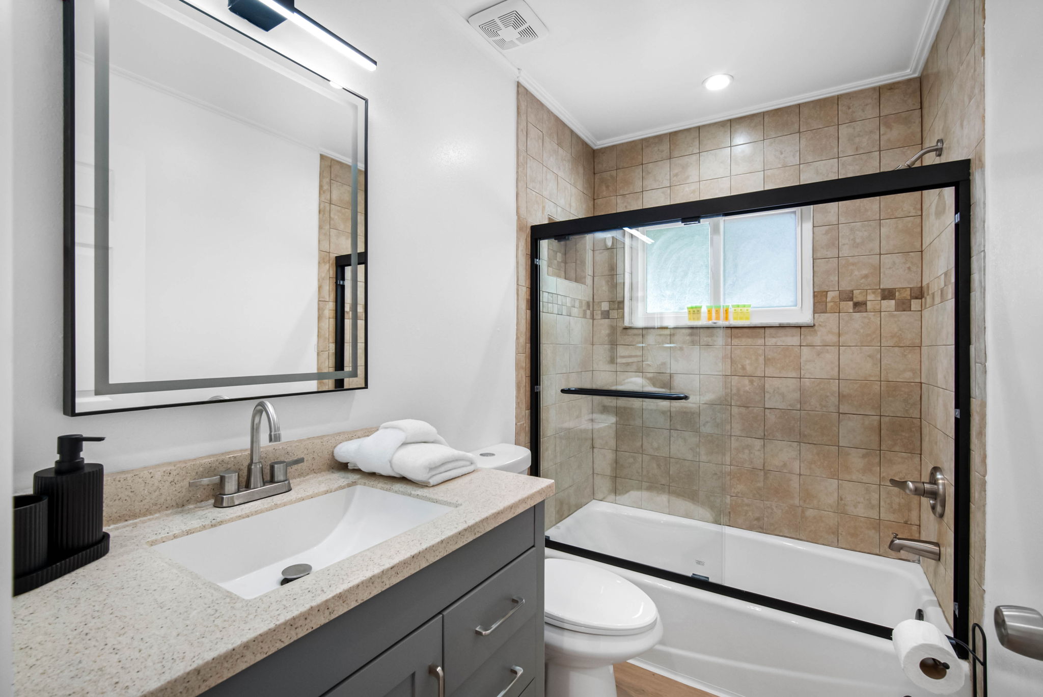 Contemporary lighting, sleek faucet hardware, and a spacious vanity bring hotel vibes to your stay.