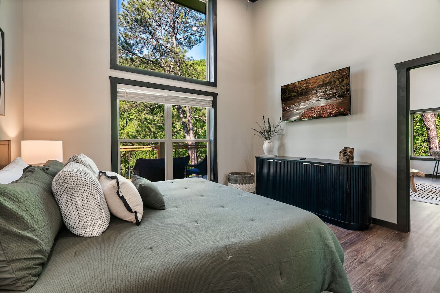 Bright king bedroom with soaring ceilings, Smart TV, and private deck access.