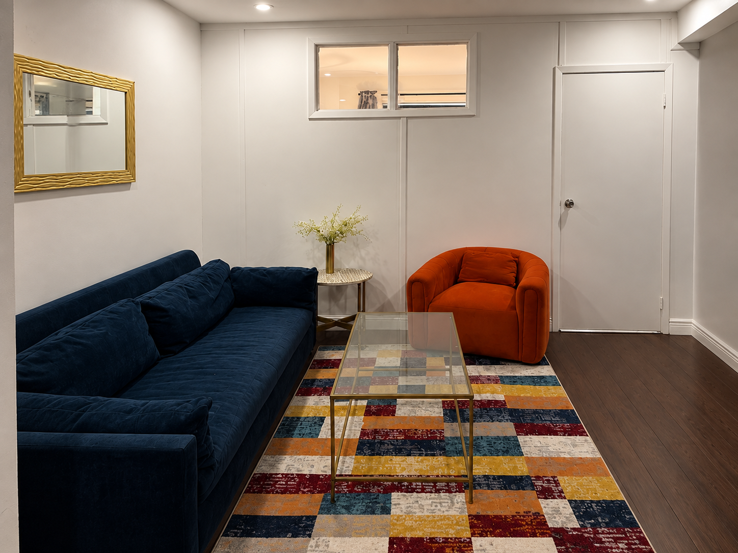 Living room with velvet sofa and vibrant area rug — 2-bedroom vacation rental in Little Italy, New York City
