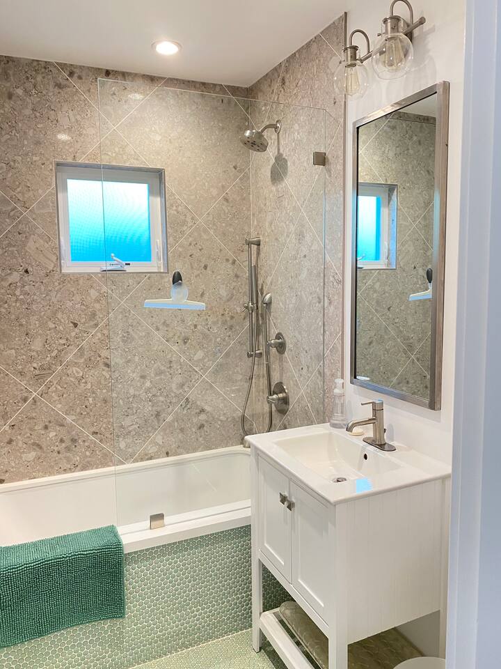 Updated bathroom with a full tub and sleek tile work.