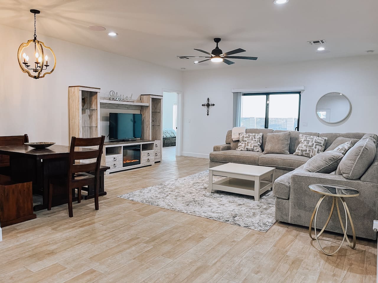 Bright and spacious living space area featuring a large sectional and entertainment center