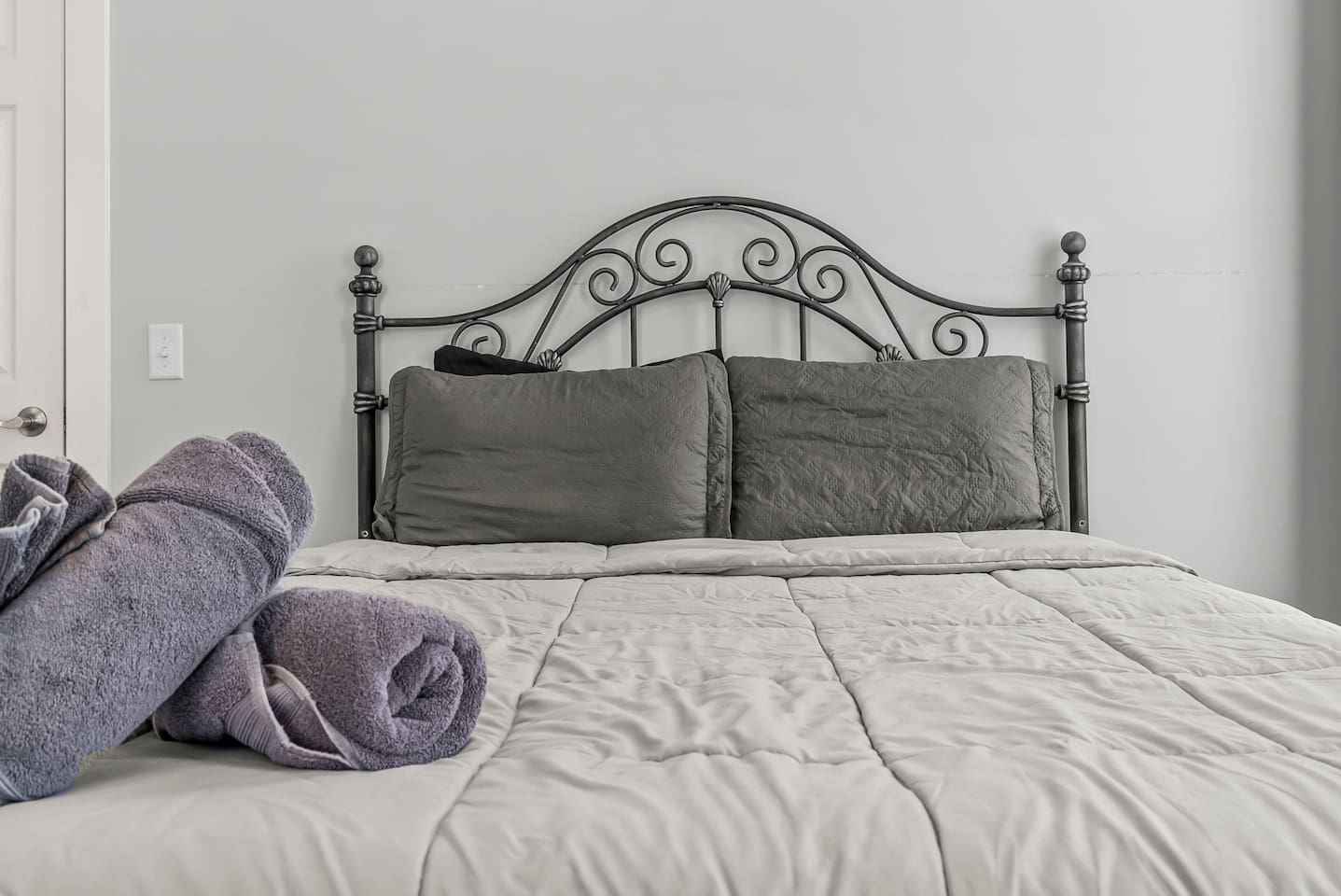 Centered bed view with neatly folded towels, creating a calm and restful sleeping atmosphere.