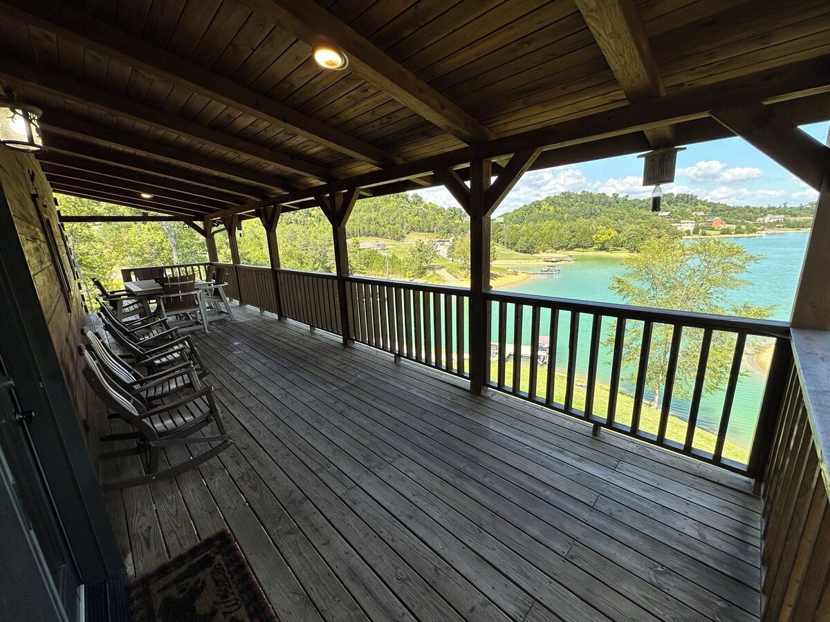 This top porch on the cabin back overlooks the lake and has great quality outdoor furniture with rocking chairs and a a large table in the back for games or eating. 