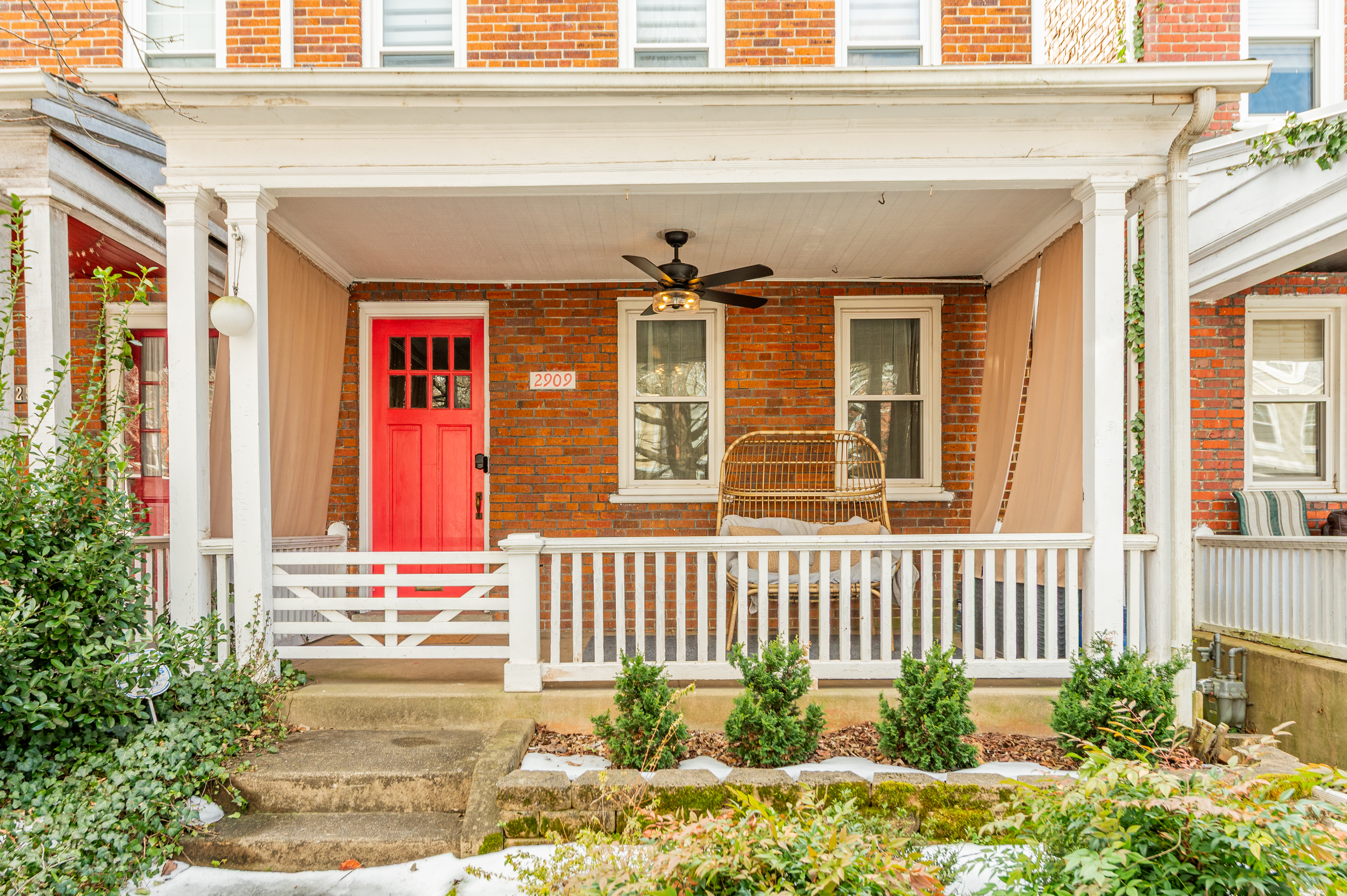 Charming Porch Retreat: Enjoy morning coffee on the vibrant porch with inviting seating and lush greenery!