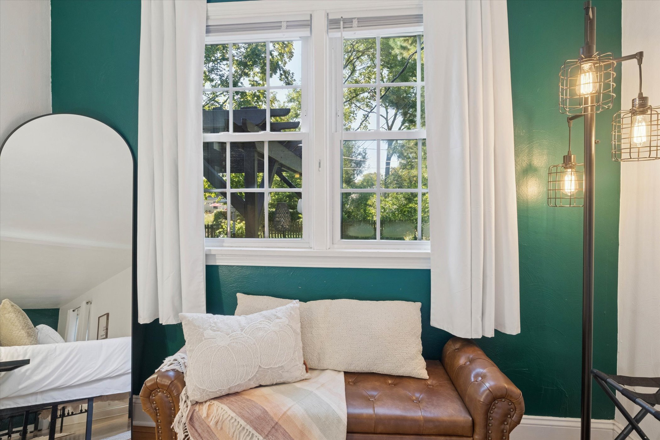 Cozy layers and garden views—our cushioned bench invites you to curl up and unwind. Soft blankets, plush pillows, a luggage rack, and hardwood floors complete this restful South Bend retreat