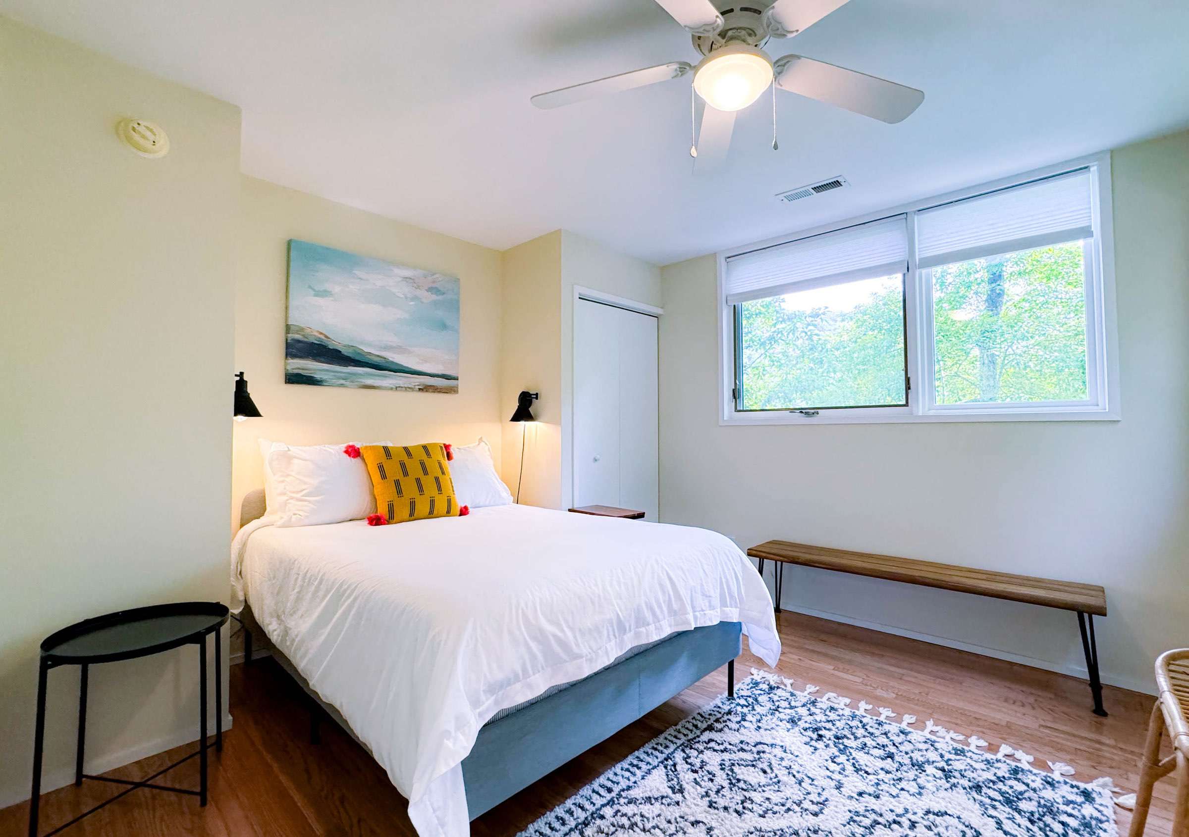 Comfy full size bed with an abundance of natural light. Enjoy the all natural tree art pictured in the windows!
