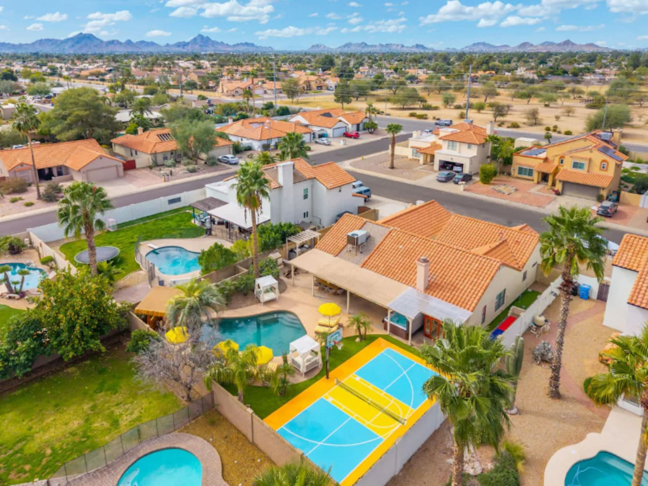 Aerial view of property with pools, sports courts, and desert mountain views—a premier Scottsdale vacation home with resort-style amenities.