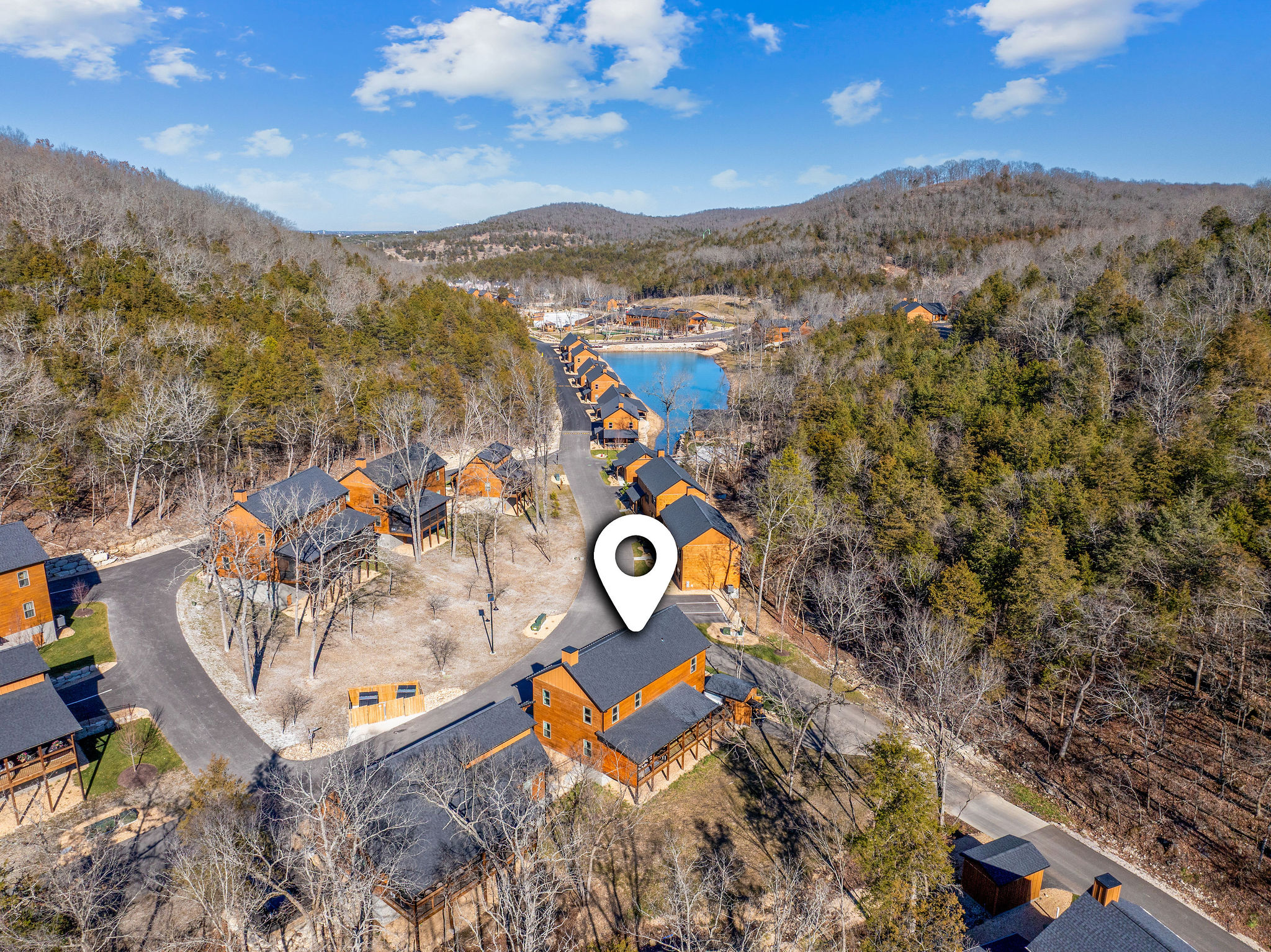 Aerial view of the cabin community, showing the peaceful wooded surroundings with hiking trails and a fishing lake just steps away.
