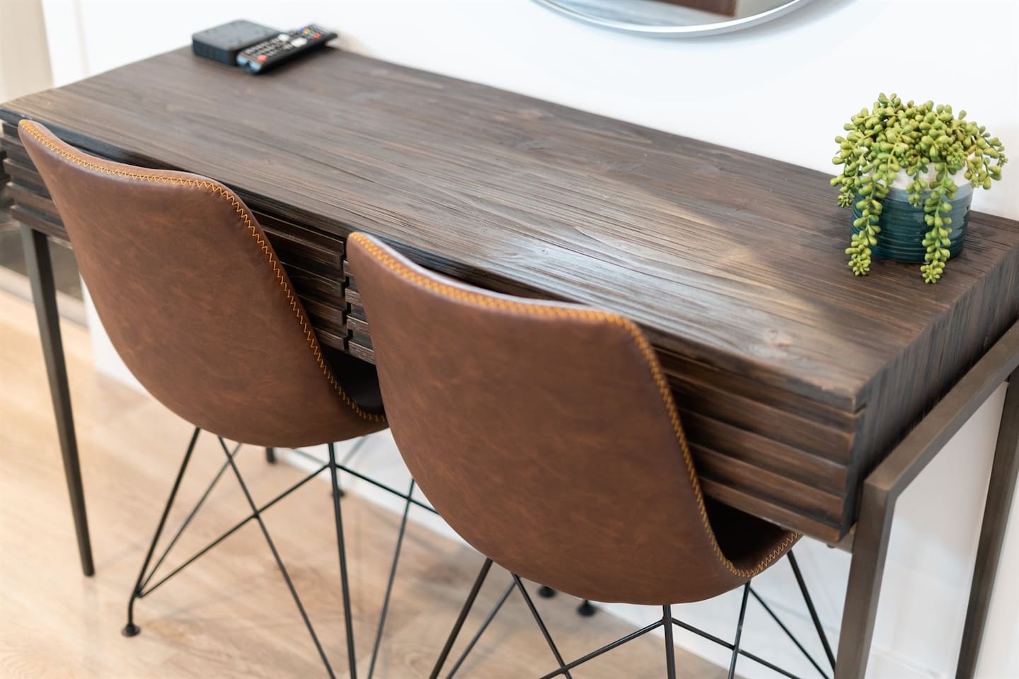 This functional seating area doubles as a home office, featuring a comfortable two-seater and a table, perfect for working or studying in style.