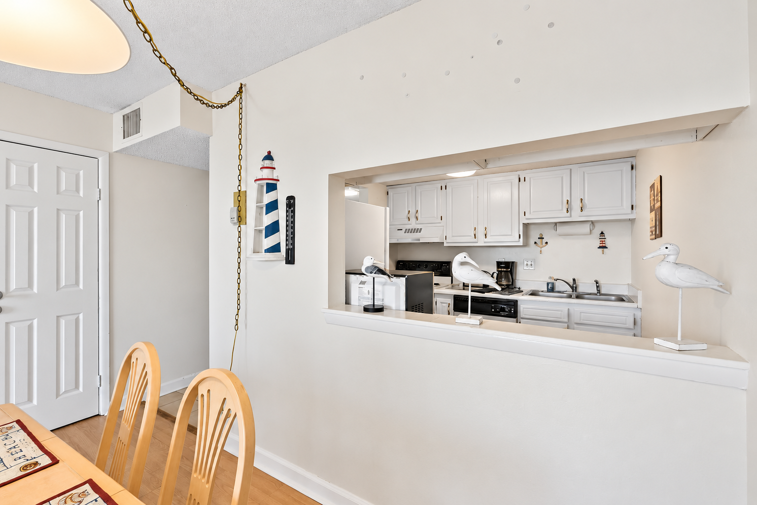 Dining pass-through window with a clear view into the kitchen, making serving meals to the six-seat dining table easier.