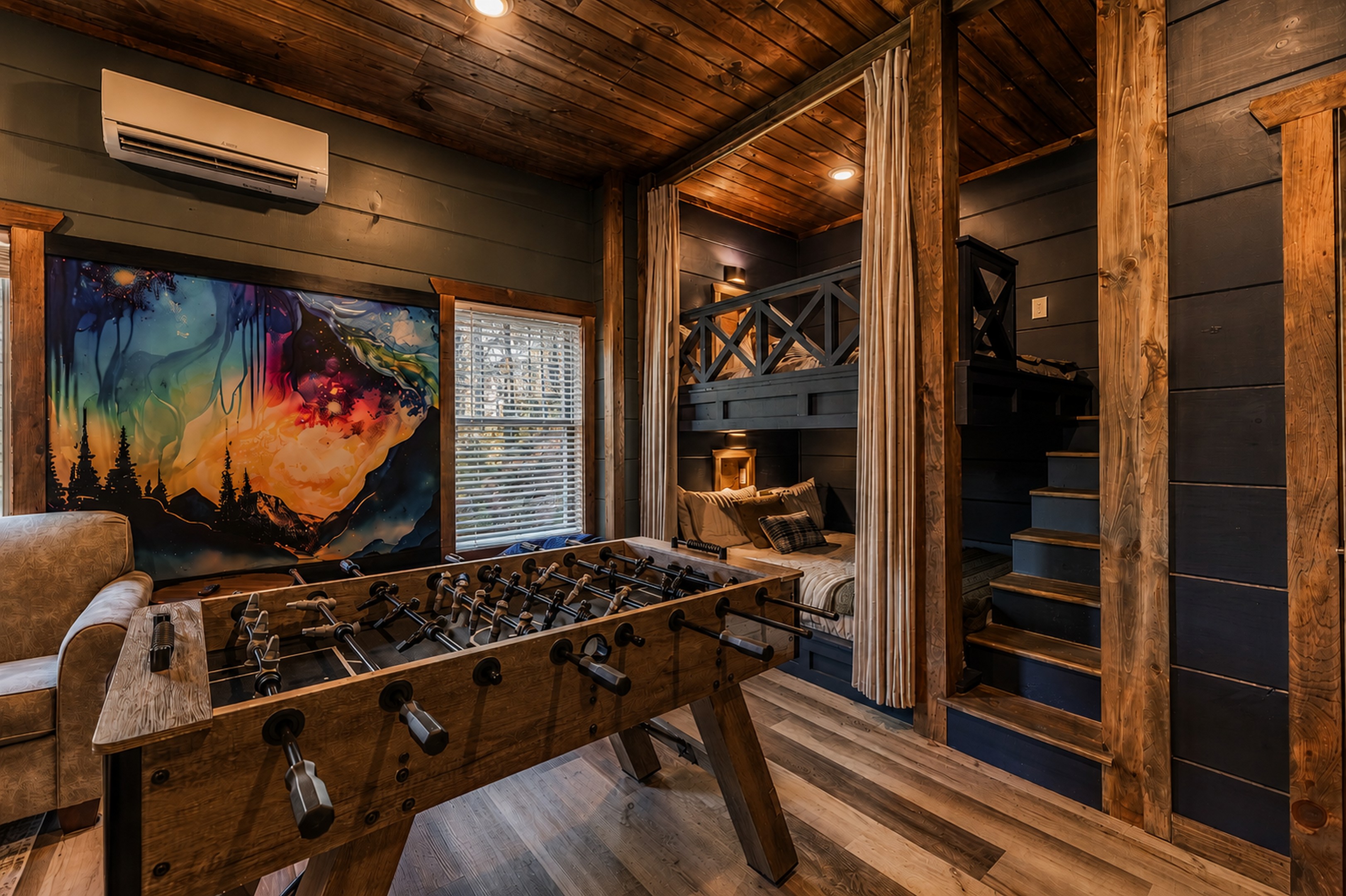 This cozy bunk room has a fun mural, foosball and incredible Queen bunks.