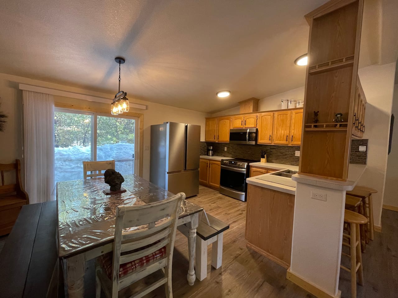 Kitchen with Updated Appliances, Backsplash, Faucet, Cupboard Door Handles, Light, Table, and Flooring