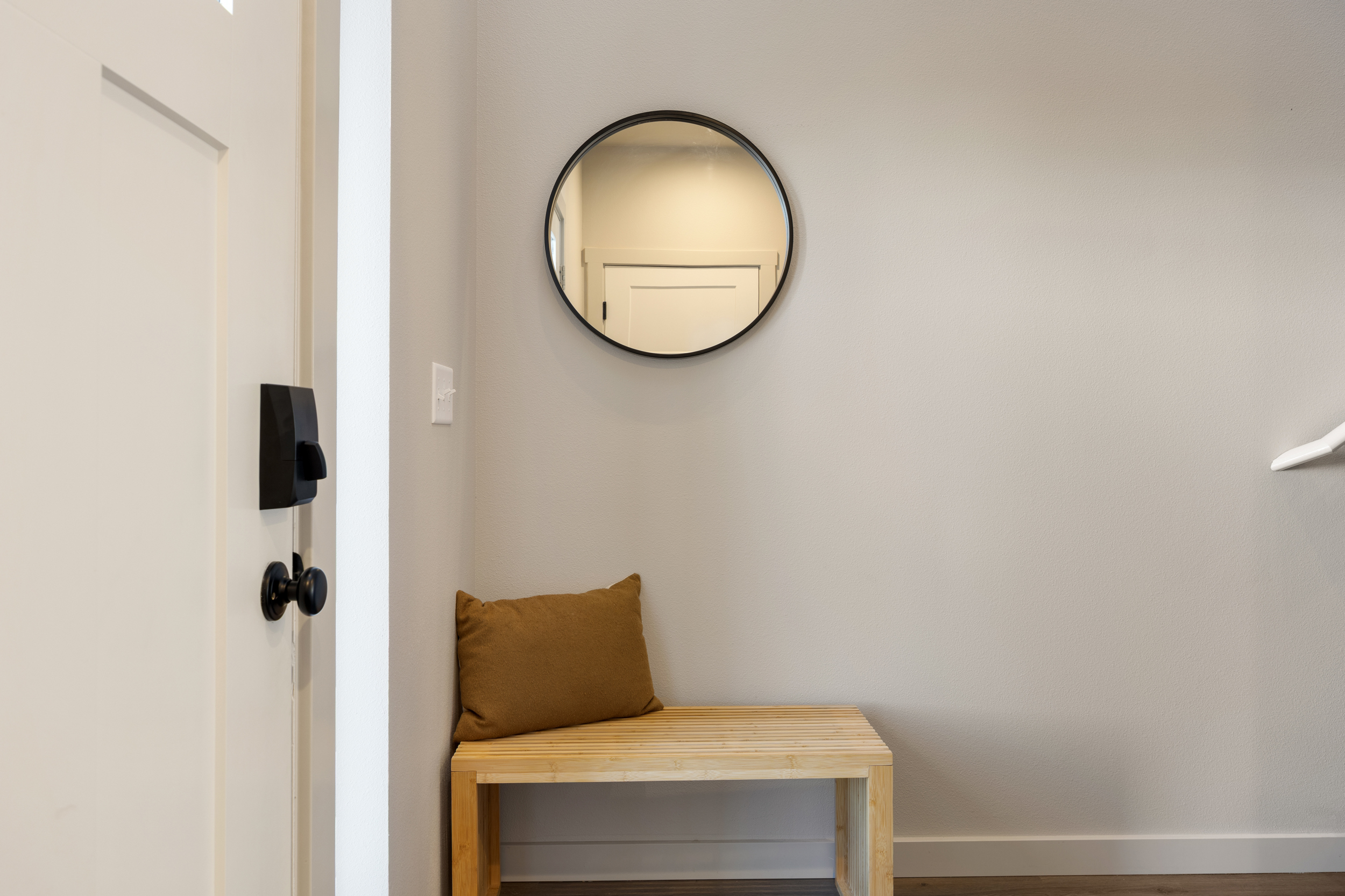 Entryway with mirror, bench, and coat hooks