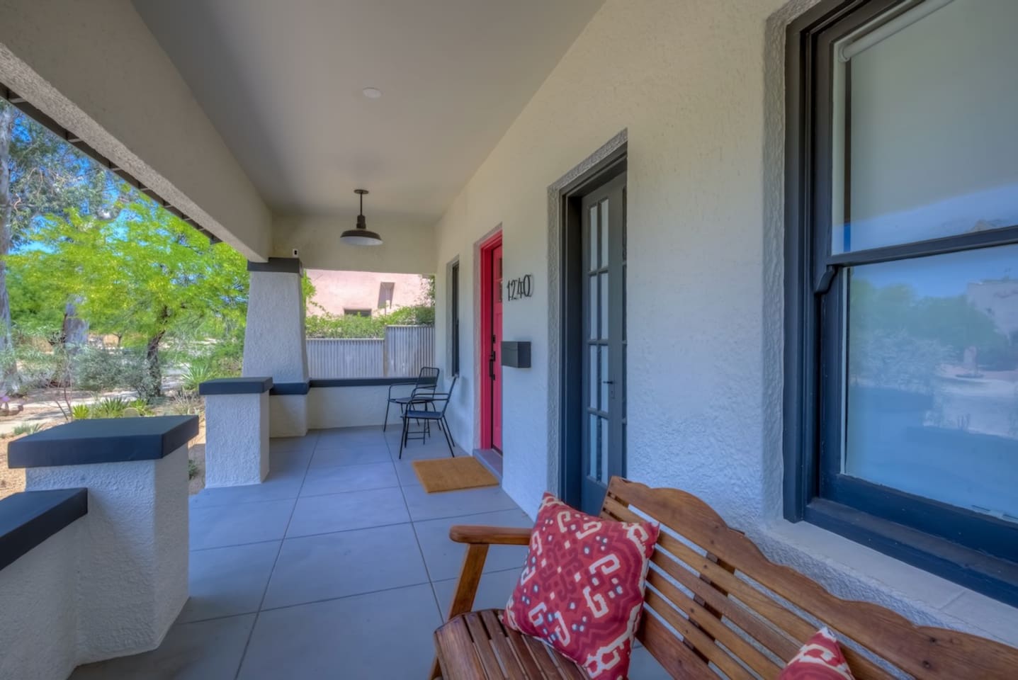 front porch with glider bench and chairs facing the sunset