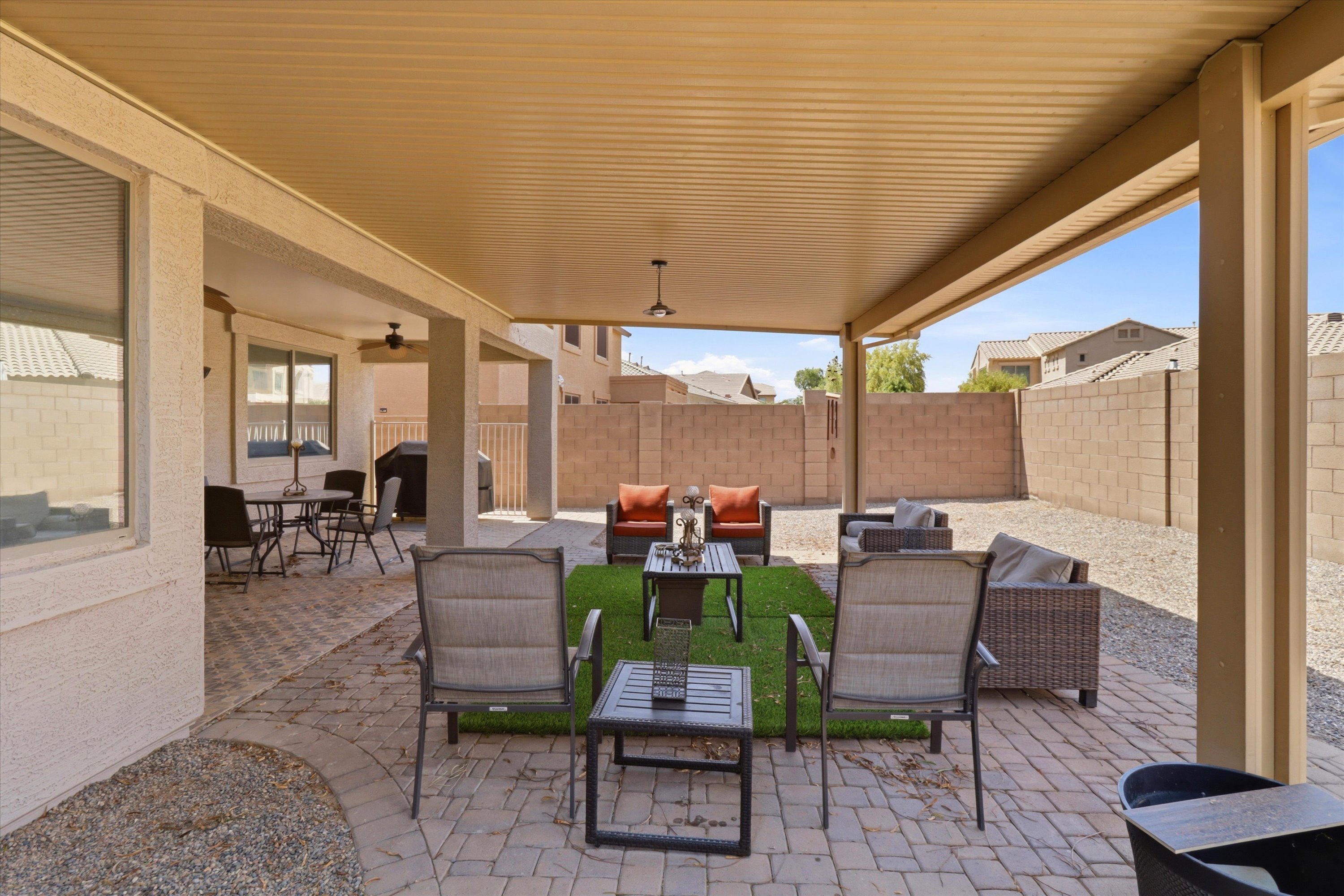 Covered backyard patio with lots of seating, a BBQ grill, and room to spend time outside.