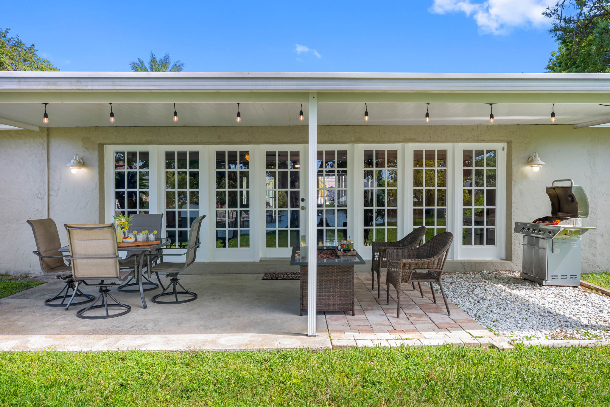Surrounded by verdant landscaping and a gentle waterway, the patio provides a natural backdrop for unwinding and entertaining.