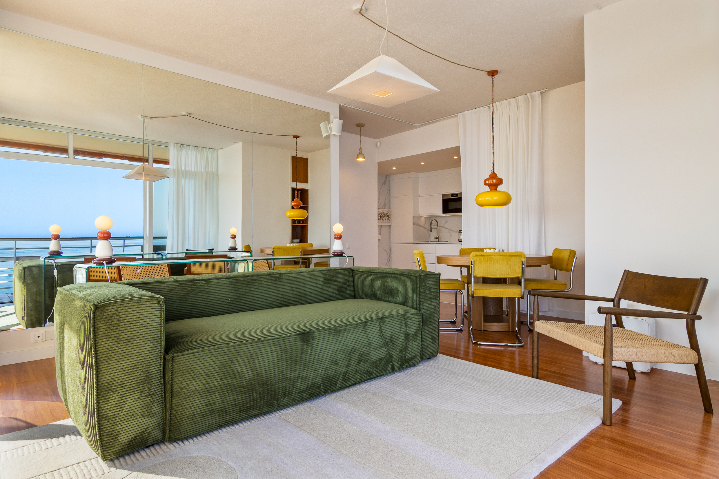 Spacious open-plan lounge and dining area with a calm retro-modern interior.
