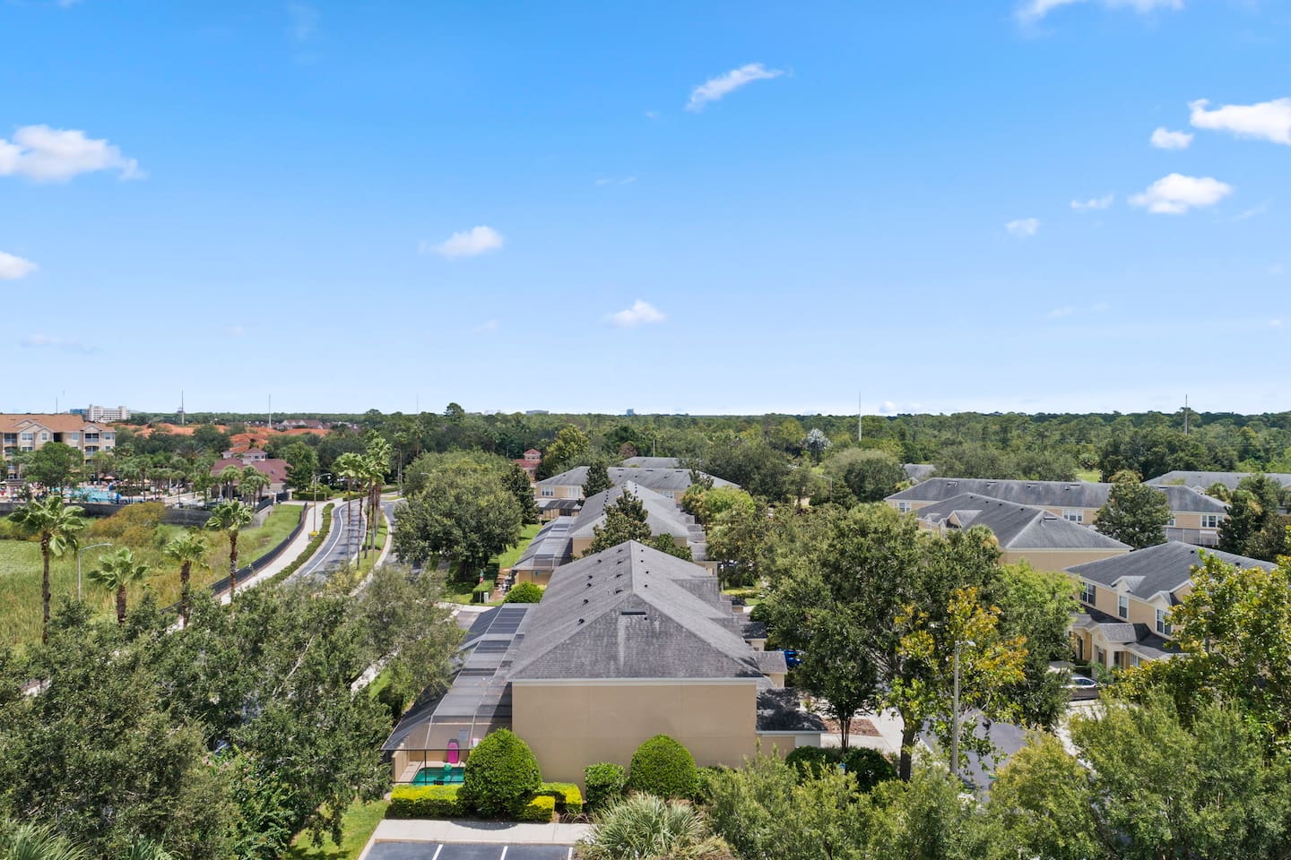 Neighborhood aerial showcasing tree lined streets and homes.

