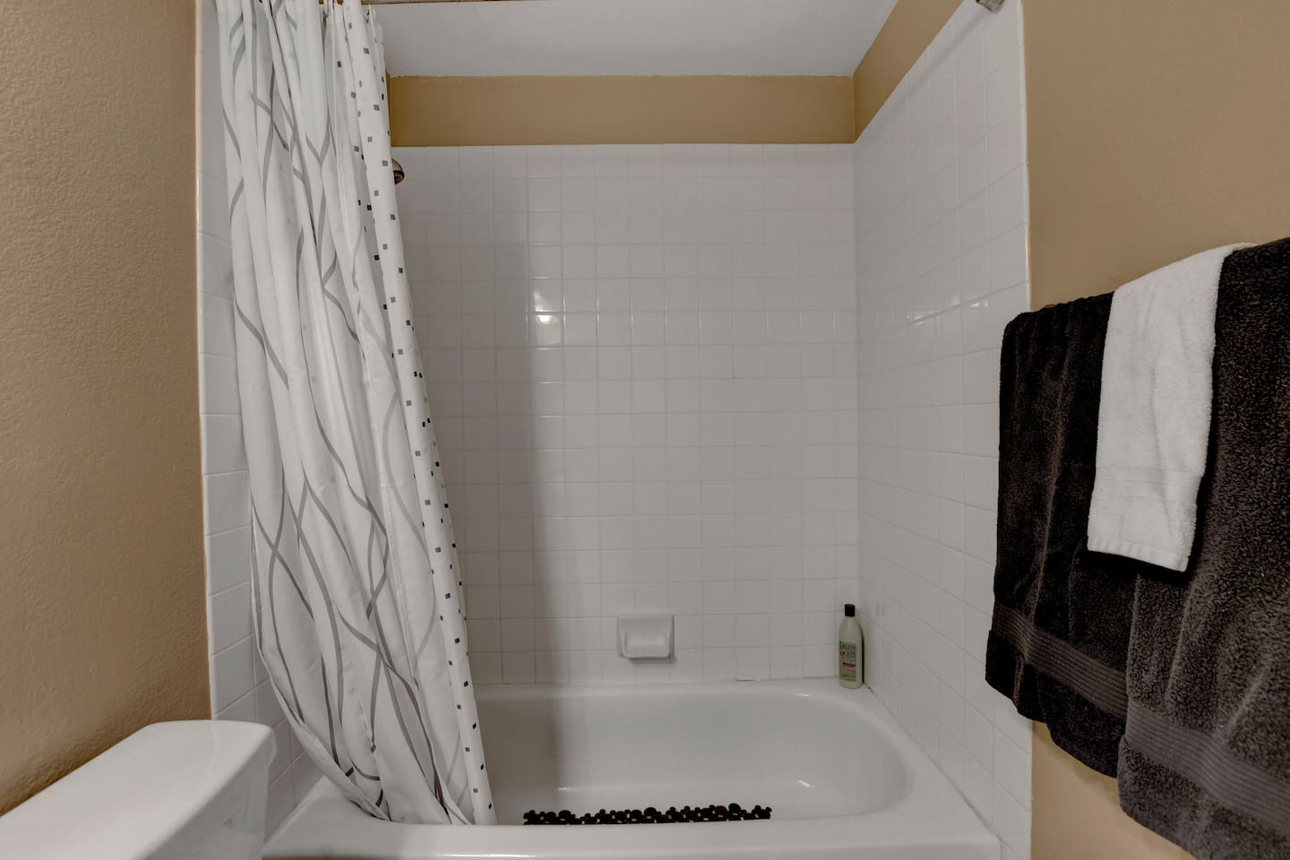 Sparkling tub/shower with plush towels and toiletries—relax and refresh.