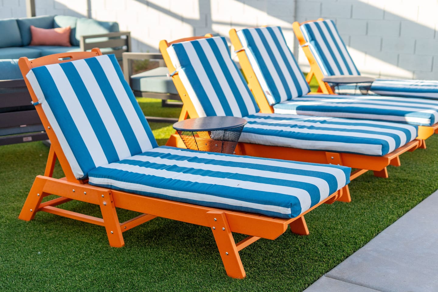 Bold orange frames with blue-and-white stripes bring a fun, beachy vibe to your poolside retreat.