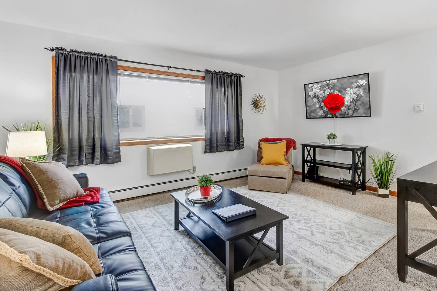 Cozy living room has blackout curtains so you can enjoy plenty of natural light or keep the light out