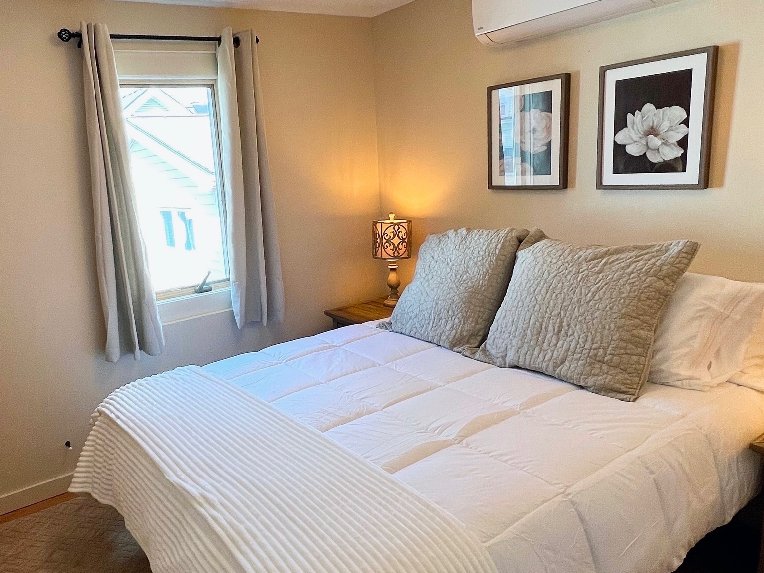 The second guest bedroom also features a queen bed with high quality linens and coastal decor.