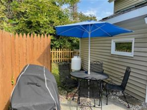 Cooperstown Cottage outdoor eating table next to the gill and the pool area.
