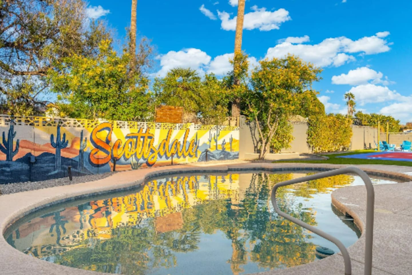 Sunlight dances across the pool by day, with the colorful Scottsdale mural reflected right on the surface.